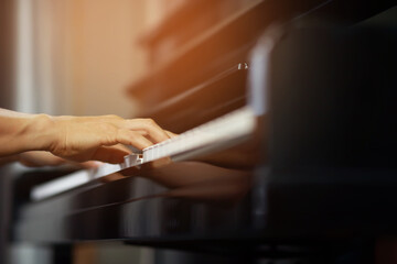 close up of hand people man musician playing piano keyboard with selective focus keys. can be used...