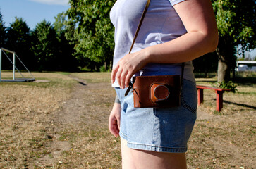 Woman holding old film camera in leather case
