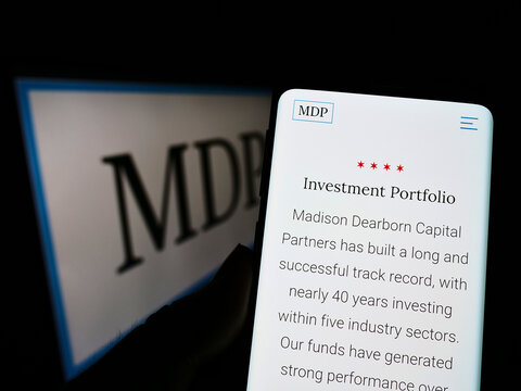 Stuttgart, Germany - 07-16-2022: Person holding cellphone with webpage of US company Madison Dearborn Partners LLC (MDP) on screen with logo. Focus on center of phone display.