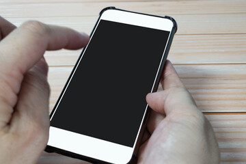 Hands holding smartphone with blurred background. Copy space.