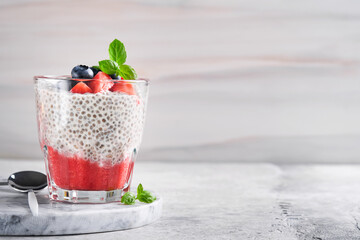 Chia strawberry pudding. Healthy vegan breakfast chia seeds pudding with fresh berries and mint in...
