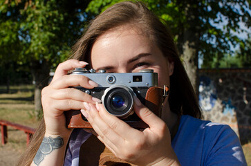 Young woman taking picture with an old/vintage film camera