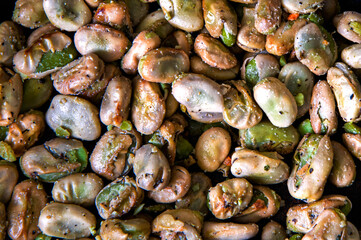 Broad beans stewed with onion and spices in a pan