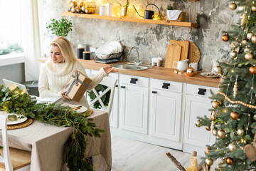 Smiling young woman using laptop near christmas tree