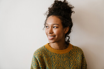 Black young woman wearing sweater smiling and looking aside