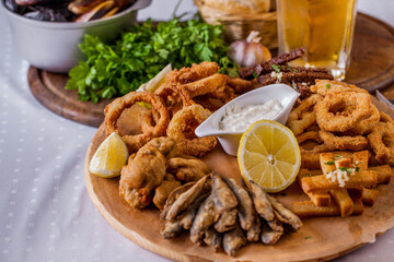 Onion rings in batter, fish in batter, rye croutons with garlic, croutons with white bread, lemon, fried wings, parsley
