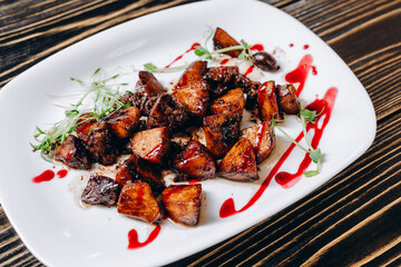 There is a white place which includes a lot of slices of fried chicken.