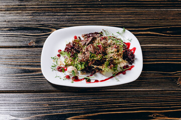 We can see a new dish of the restaurant on the brown wooden table.