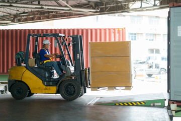 Forklift are loading into cargo containers at warehouses, ports, freight forwarding, cargo supply chains, cargo transportation, warehouse industry, logistics. © ake1150