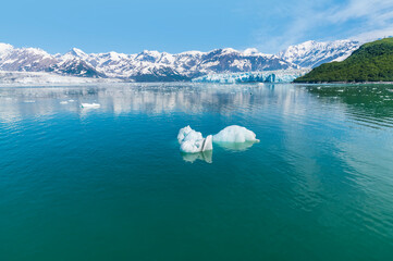 A view past an iceberg towards the Hubbard and Valerie Glaciers in Alaska in summertime