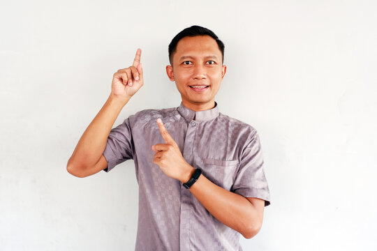 Happy man pointing up to empty space isolated on white background.