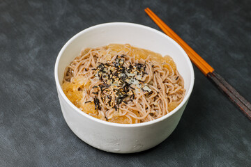 Korean food Naengmemilguksu, a winter delicacy, this buckwheat noodle dish is served in a cold chicken- or beef-based broth and topped with cold slices of beef and egg as a garnish.