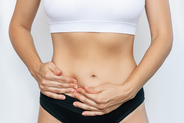 Cropped shot of a young woman holding her side with her hands isolated on a white background. Ache in the lower abdomen. Stomach pain. Gynecological problems, cyst, inflammation of the ovary