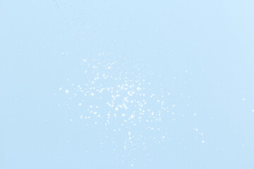 Sparkling silver glitter on blue background. Holiday blurred lights