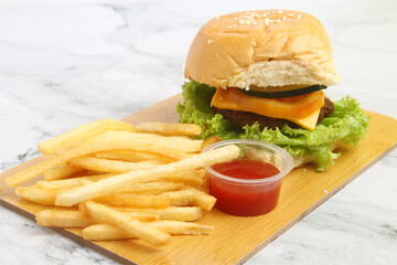 Freshly made hamburger with cheese sandwich and french fries