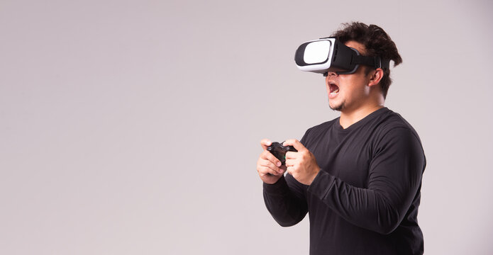 Asian man touching air, wearing VR headset, glasses or gadget. Man plays VR game ,Futer technology of modern concept.