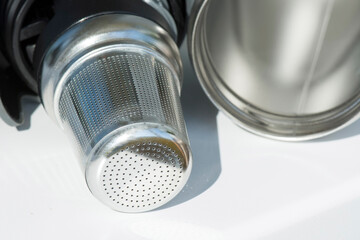 Stainless steel tea strainer infuser close up. Tool for thermos or coffee mug with spill proof lid.