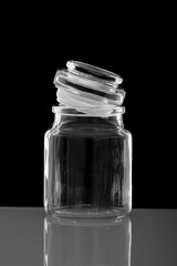 Glass apothecary jar with lid ajar and reflective surface image