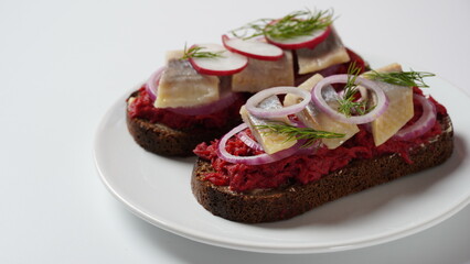 Danish open sandwich Smorrebrod on dark rye bread with herring, salmon, beetroot, red onions, and radish