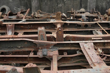 a collection of broken metal truck chassis for sale at a junk metal shop