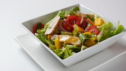 Salad with chicken breast, fresh mango, avocado, cucumber, cherry tomatoes, lettuce. Healthy food concept