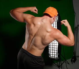 Athletic Football Player Posing and Flexing Muscles © KCULP