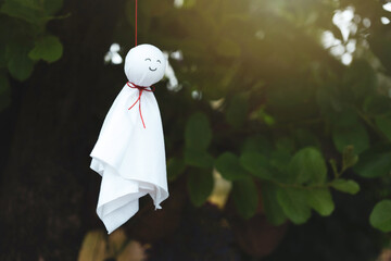 Chasing rain Japanese doll or Teru Teru Bozu hanging on branches tree in the garden and background...