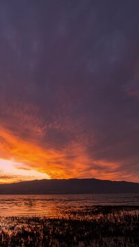 Time lapse looking over Utah Lake during colorful sunset over Lake Mountain as the clouds change colors in the sky.