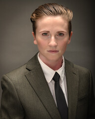 Young, attractive, gender non-binary, Los Angeles citizen poses in studio wearing a suit and tie. 
