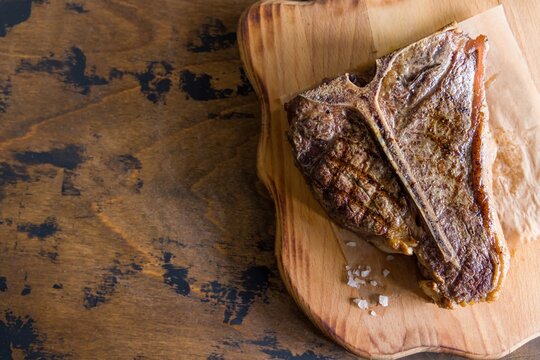 Steak T Bone, tibon steak, steak on bone on wooden table top view with copy space for text