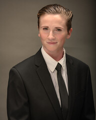 Young, attractive, gender non-binary, Los Angeles citizen poses in studio wearing a suit and tie. 