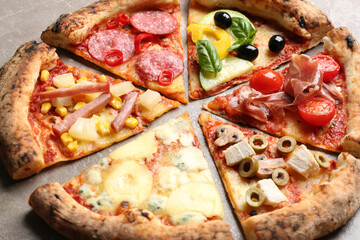 Slices of different delicious pizzas on table, closeup
