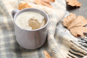 Cup of coffee on warm plaid, closeup view
