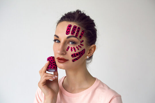Woman With Pink Kinesio Tape In The Leopard Coloring On Her Face
