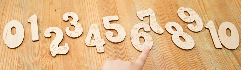 Wooden jigsaw digits from 0 to 10 on natural wood table. Learning numbers. Toy for preschool Kids....