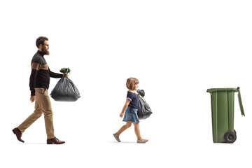 Father and daughter with plastic bags walking towards a trush bin