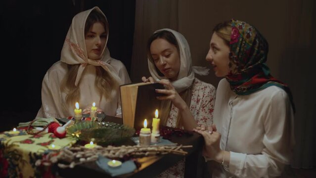 4K. Slavic women fortune-telling in a dark room by candlelight