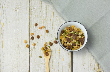 Chopped nuts in bowl and spoon on table, overhead view