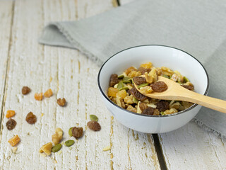 Chopped dry fruits in the bowl with wooden spoon on the table
