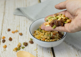 Hand picking up pieces of dried fruit for salad