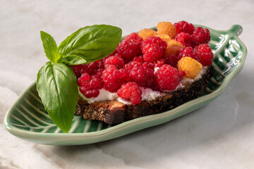 Sandwiches with cream cheese and berries combined with basil. Summer snack for breakfast or snack.