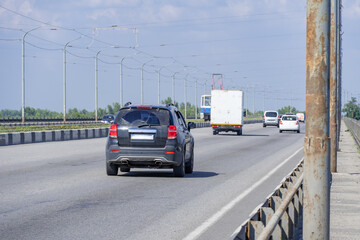 Transport on the road bridge in summer day. Panorama on bridge for truck and car and tram passenger transport. Tramline. Infrastructure Dnipro Ukraine. Speed ​​limit.