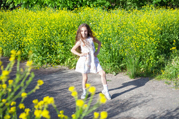 Fototapeta premium a girl with long flowing hair stands among the grass.