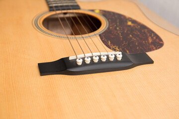 Fototapeta premium A fragment of the body of an acoustic six-string guitar.