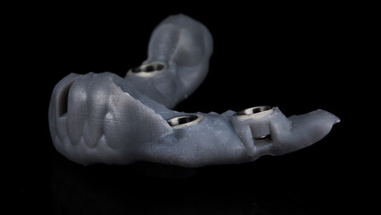 gray surgical dental template for implantation on a black background