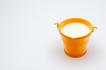 full orange bucket with milk on white background