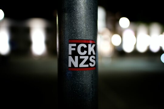 Close-up shot of the FCK NZS popular anti-nazi acronym posted on a street pole