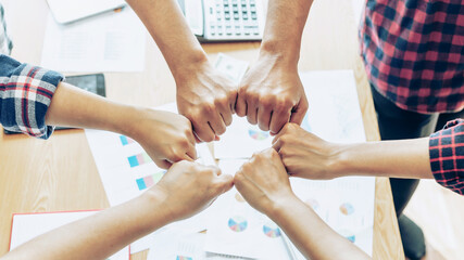 Obraz premium close up hand of business partnerships people bump hands finishing up meeting showing unity over office desk , business teamwork concept