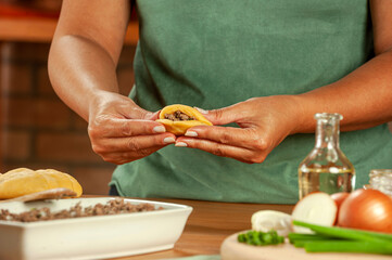 Obraz na płótnie Canvas Woman preparing brazilian snacks beef stufing croquette (risolis de carne)