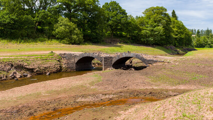 A normally submerged old bridge at a near empty reservoir during a heatwave
